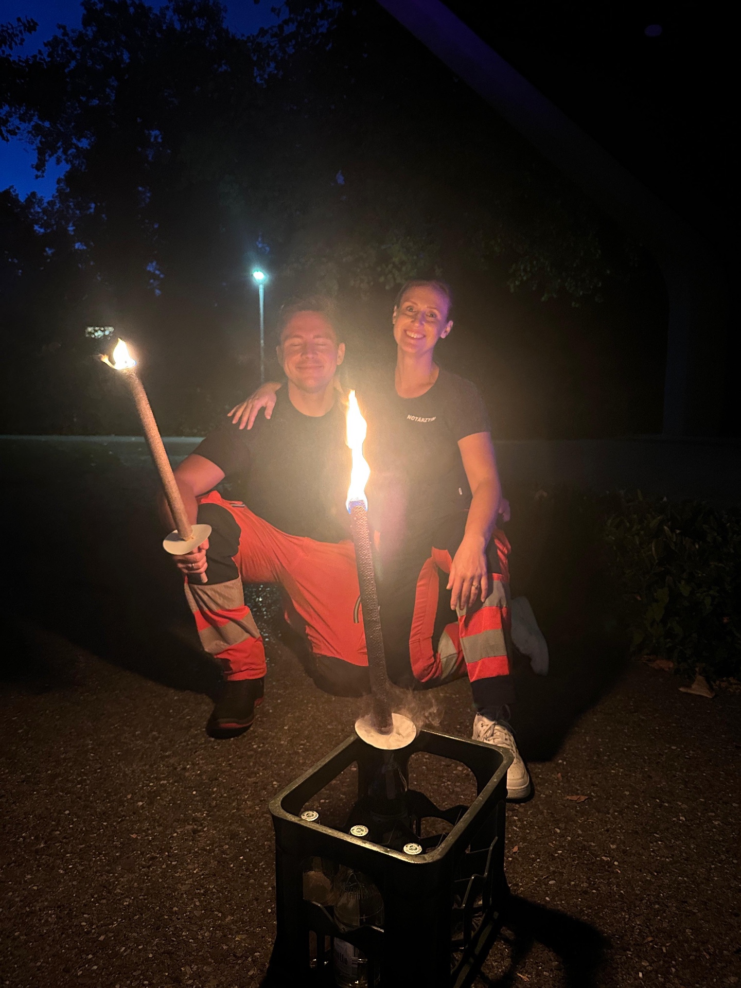 Das Team des Aktionstags steht am Abend in Einsatzkleidung mit Fackeln zusammen.