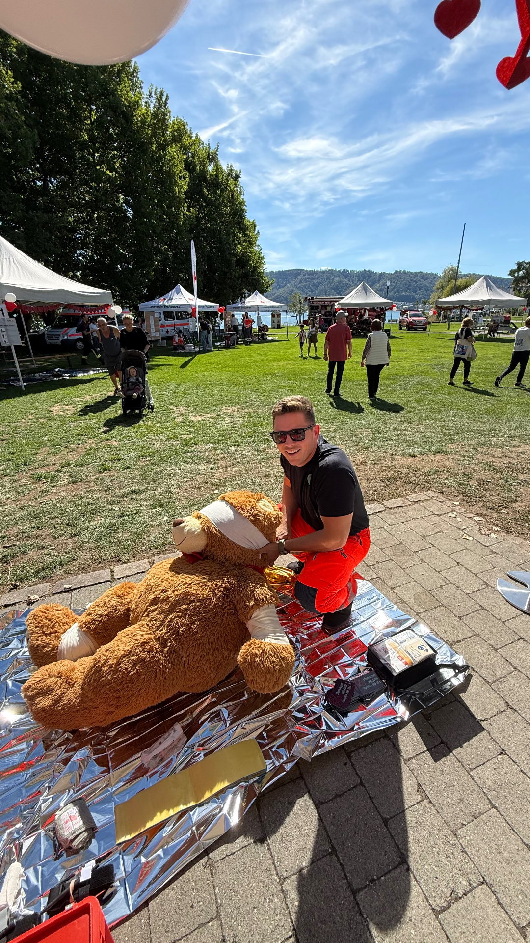 Tom Vormeyer übt mit Kindern ab 2 Jahren an dem großen Reanimations-Teddy, an dem auch Verbände aller Art inklusive Tourniquets zum Ausprobieren bereitlagen.